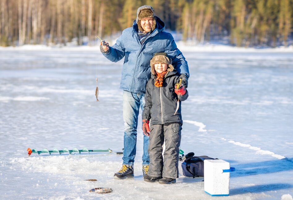 Aufnahme Vater und Sohn auf einem zugefrorenen See mit Angelausrüstung