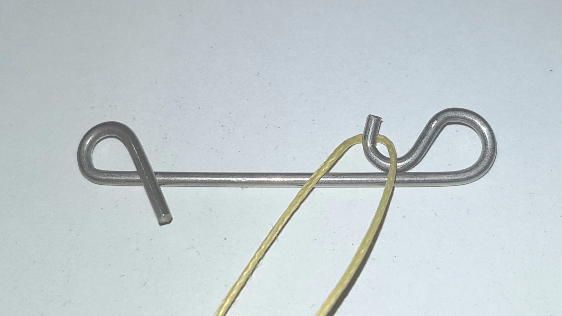 Nahaufnahme, die Schlaufe der geflochtenen Schnur liegt um einen Schnurverbinder.